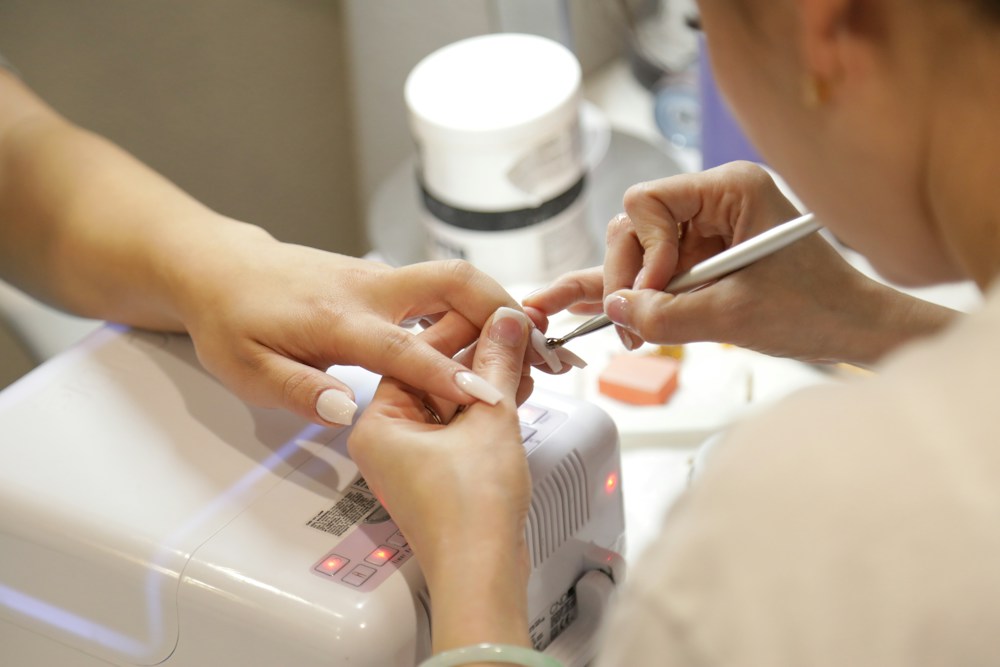 Una profesional trabajando con cuidado en las uñas de una clienta