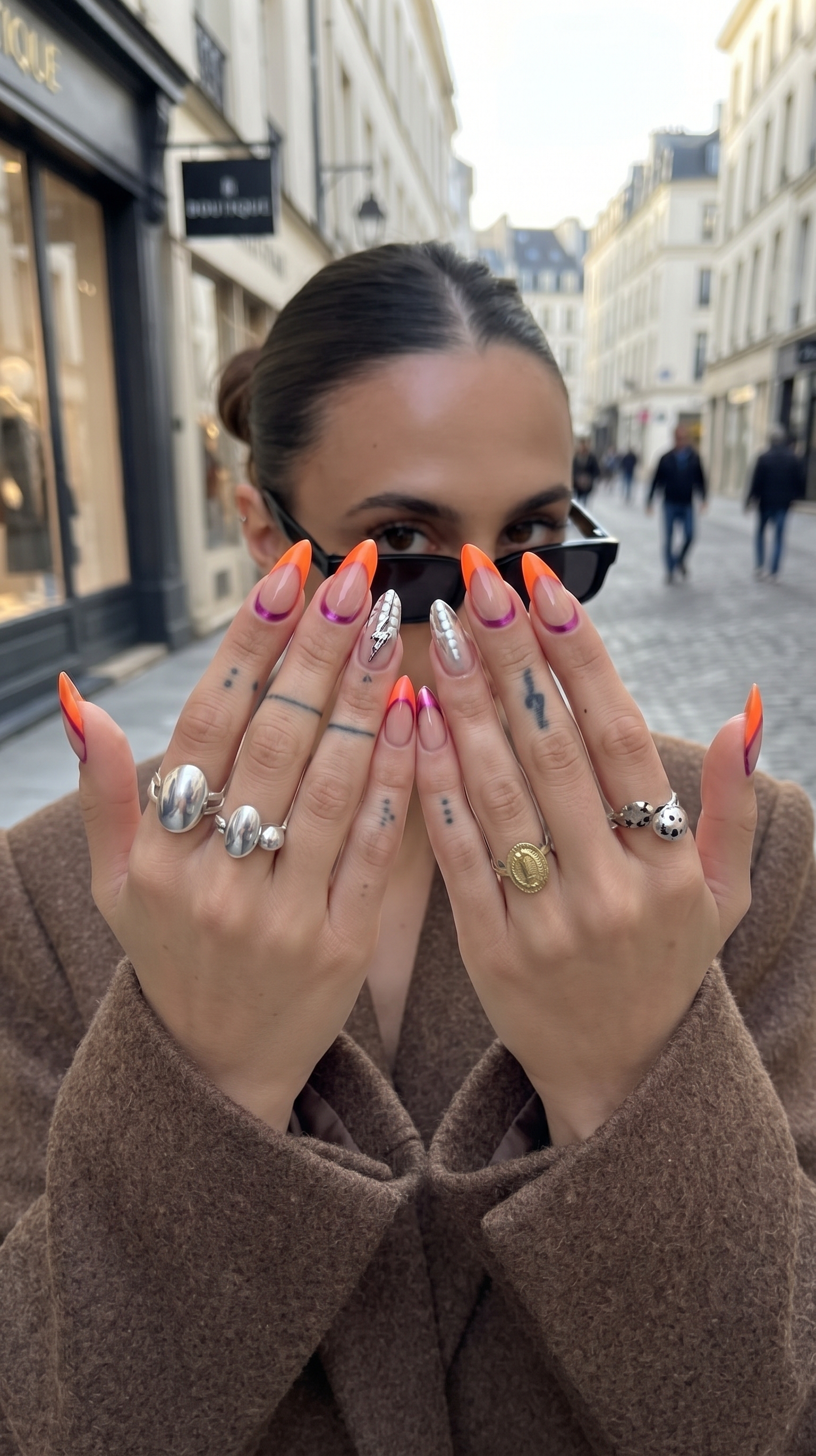 Diseño de uñas con detalles brillantes sobre esmalte oscuro