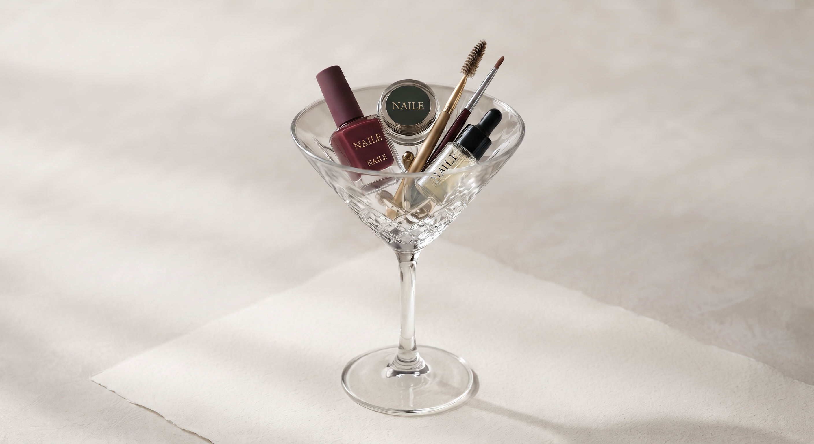 Copa de cristal con esmaltes, pinceles y productos de manicura Naile